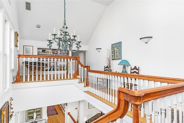 interior space with hardwood / wood-style floors, high vaulted ceiling, and an inviting chandelier