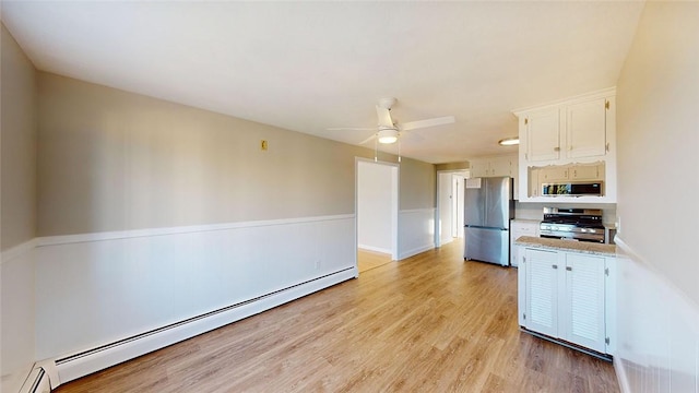 kitchen featuring appliances with stainless steel finishes, ceiling fan, a baseboard heating unit, light hardwood / wood-style flooring, and white cabinets