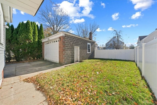 view of yard with a garage and an outbuilding