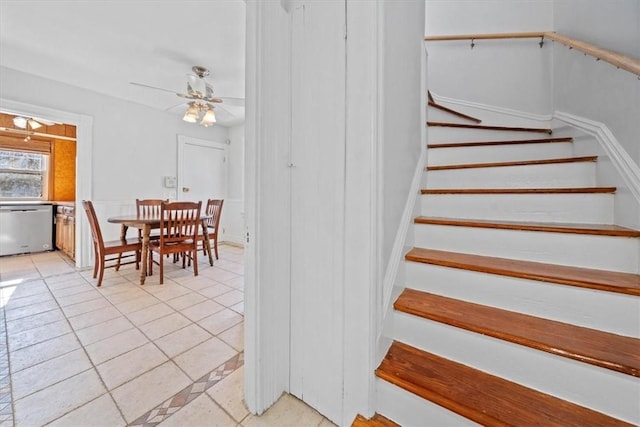 stairway featuring tile patterned flooring and ceiling fan