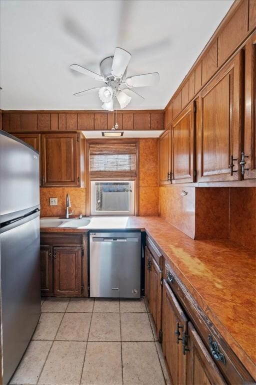 kitchen with ceiling fan, sink, stainless steel appliances, tasteful backsplash, and light tile patterned floors