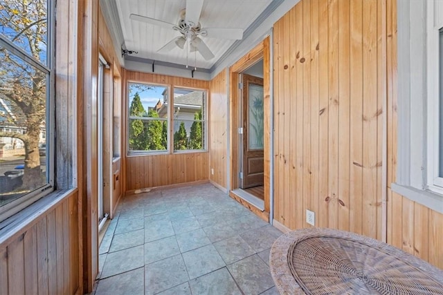 unfurnished sunroom featuring ceiling fan