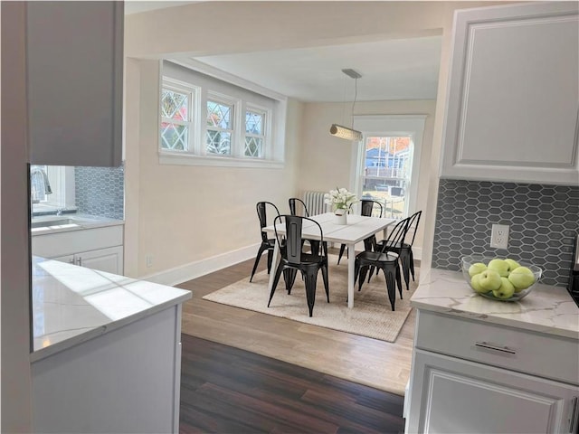 dining space with dark hardwood / wood-style flooring and sink