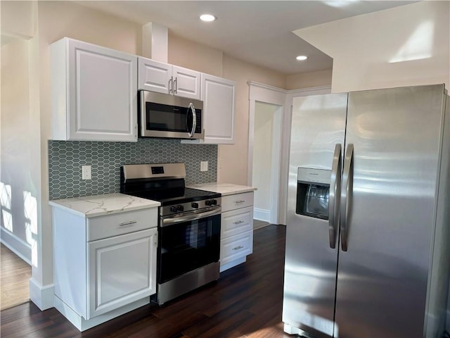 kitchen featuring backsplash, light stone counters, stainless steel appliances, dark wood-type flooring, and white cabinetry