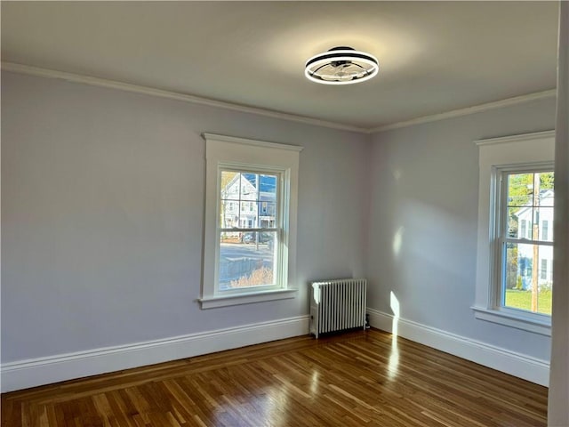 unfurnished room featuring radiator heating unit, dark hardwood / wood-style floors, plenty of natural light, and ornamental molding