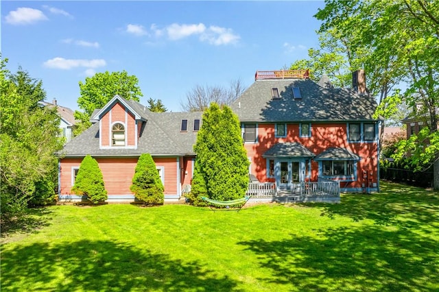 rear view of house featuring a lawn