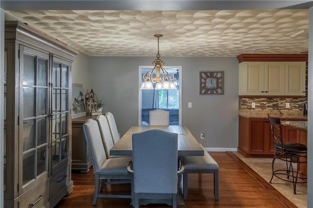 dining room with hardwood / wood-style floors and an inviting chandelier