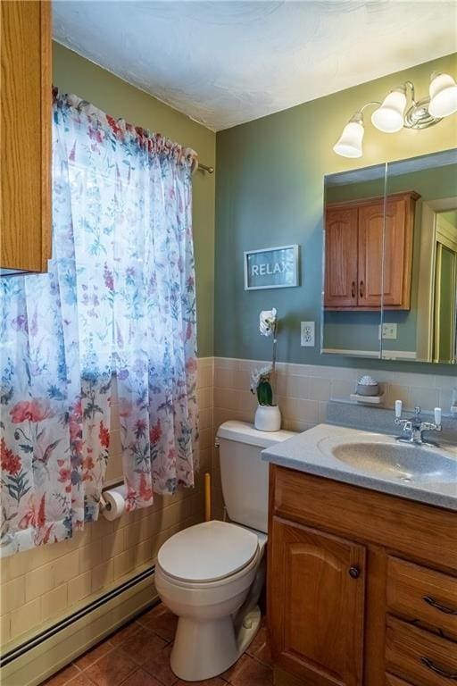 bathroom with vanity, a baseboard heating unit, tile walls, tile patterned flooring, and toilet