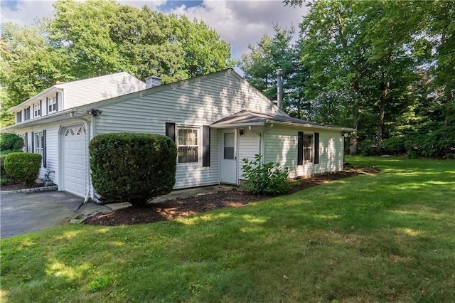 view of side of property featuring a yard and a garage