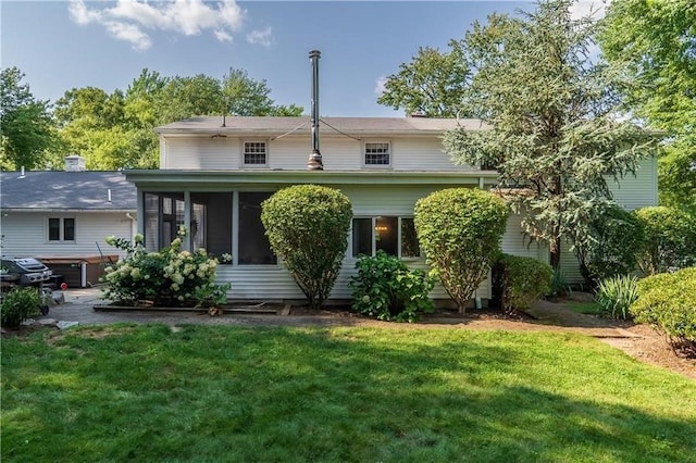 back of house featuring a sunroom and a yard