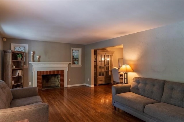 living room with a fireplace and dark wood-type flooring