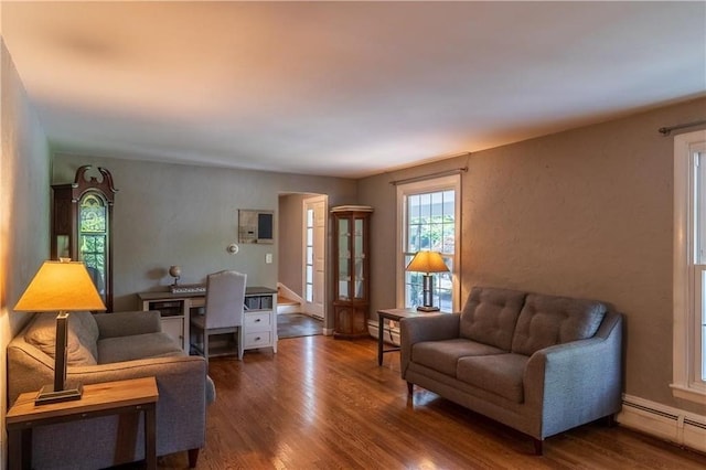 living room with dark hardwood / wood-style flooring and a baseboard heating unit