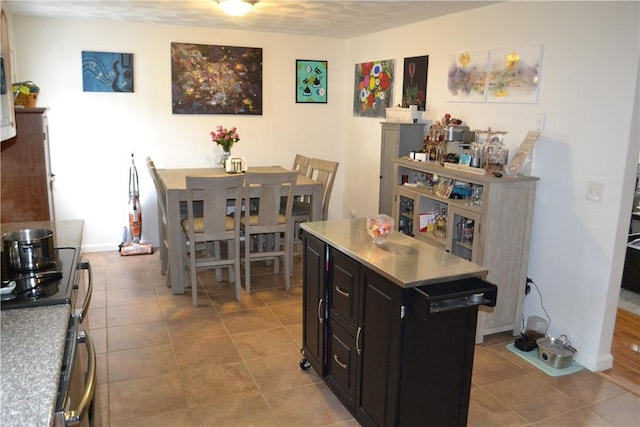 kitchen featuring light tile patterned floors, a center island, and stainless steel range oven