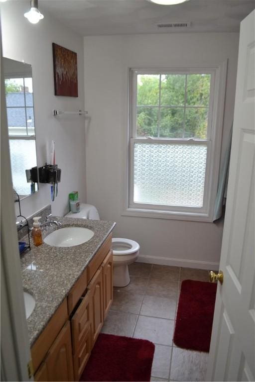 bathroom featuring tile patterned flooring, vanity, and toilet