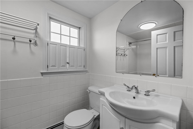 bathroom with vanity, toilet, tile walls, and a baseboard heating unit