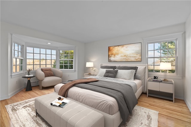 bedroom with multiple windows and light hardwood / wood-style flooring