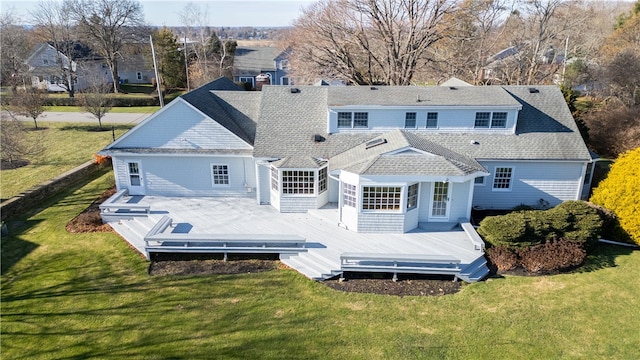 rear view of house featuring a deck and a lawn