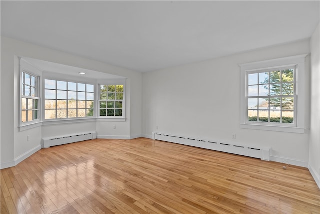 unfurnished room with light hardwood / wood-style flooring and baseboard heating