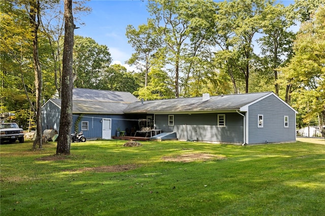 rear view of property featuring a lawn