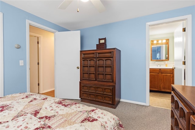 bedroom featuring ceiling fan, light colored carpet, sink, and connected bathroom