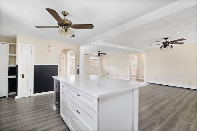 kitchen featuring white cabinets, dark wood finished floors, a kitchen island, open floor plan, and a baseboard heating unit