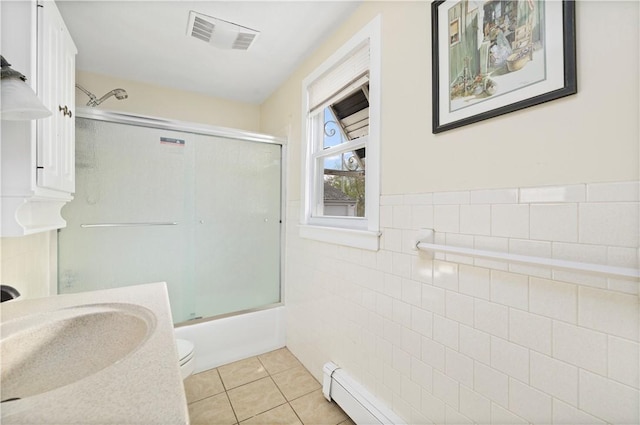 full bathroom with toilet, shower / bath combination with glass door, tile walls, visible vents, and tile patterned floors