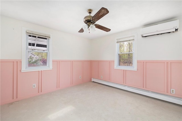 empty room with light carpet, a ceiling fan, a wainscoted wall, a wall mounted air conditioner, and a baseboard heating unit