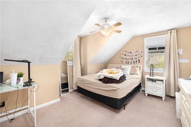 bedroom with light carpet, baseboards, a textured ceiling, and lofted ceiling