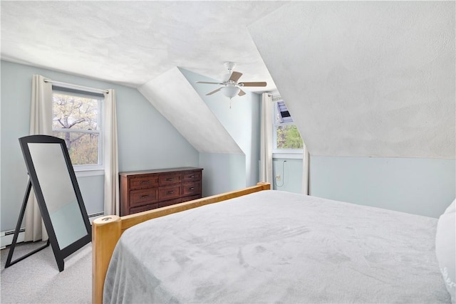 bedroom with ceiling fan, carpet, baseboards, and vaulted ceiling