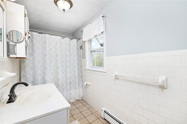 bathroom with tile walls, a baseboard heating unit, wainscoting, vanity, and tile patterned floors