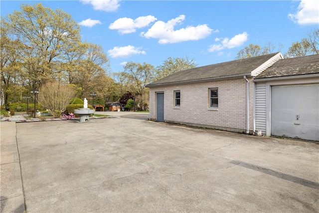 view of side of property featuring a garage and brick siding