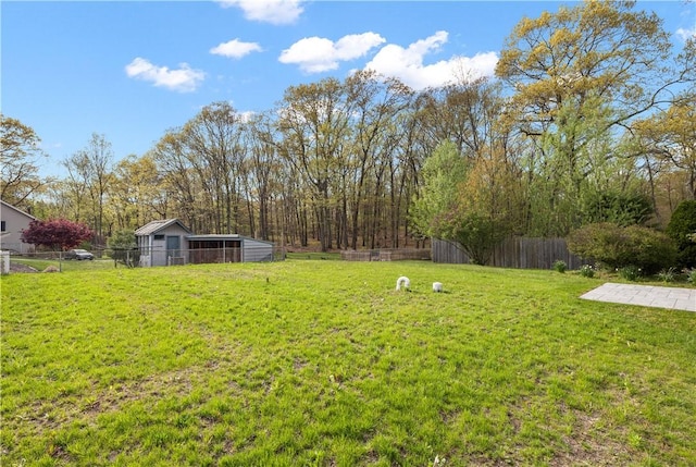 view of yard featuring an outbuilding and fence