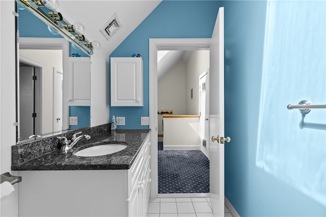 bathroom featuring tile patterned flooring, vanity, and lofted ceiling