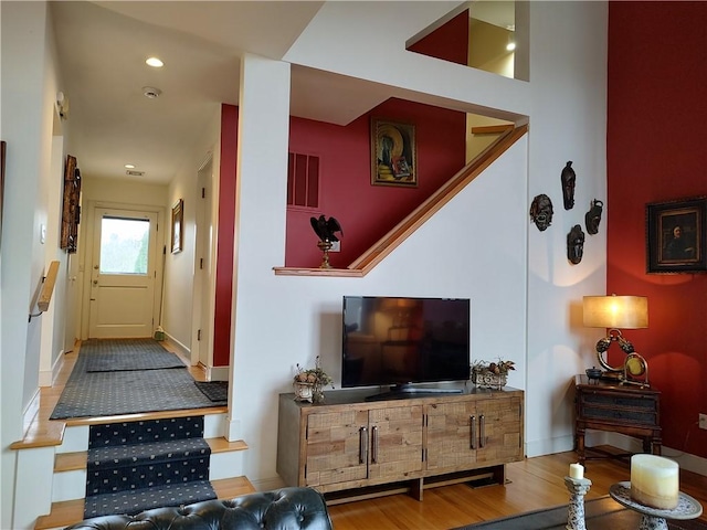 living room with light hardwood / wood-style floors and a high ceiling