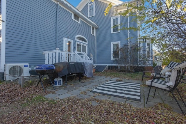 rear view of house with ac unit and a patio area