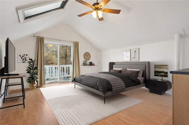 bedroom featuring access to outside, ceiling fan, vaulted ceiling with skylight, and light wood-type flooring