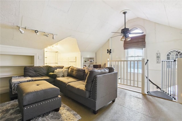 living room with built in features, rail lighting, vaulted ceiling, and ceiling fan