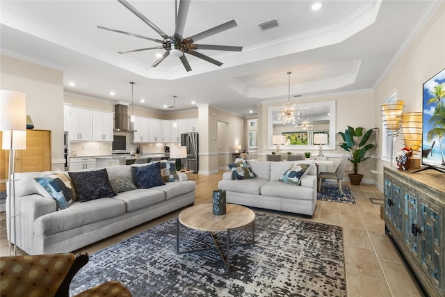 tiled living room featuring a raised ceiling, crown molding, and ceiling fan with notable chandelier