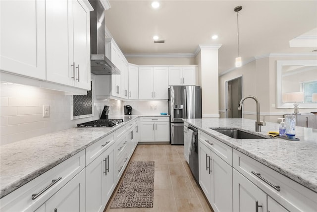 kitchen with white cabinetry, sink, light stone counters, and wall chimney range hood