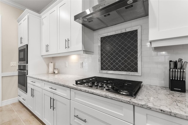 kitchen with white cabinets, wall chimney exhaust hood, decorative backsplash, appliances with stainless steel finishes, and light stone counters