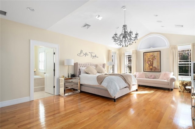 bedroom featuring ensuite bathroom, lofted ceiling, and light hardwood / wood-style flooring