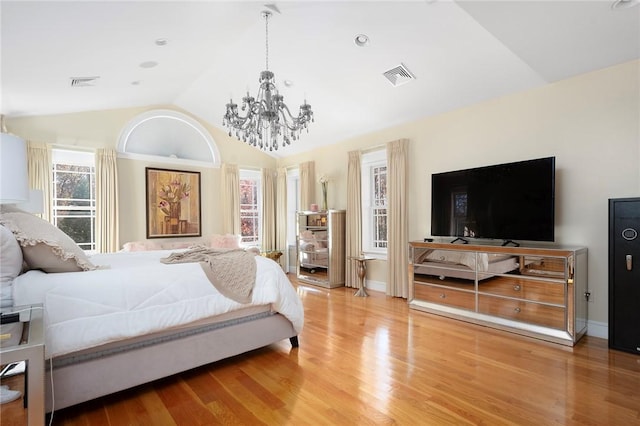 bedroom featuring hardwood / wood-style floors, vaulted ceiling, and a notable chandelier