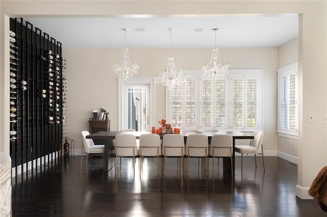 dining area with dark hardwood / wood-style floors and an inviting chandelier