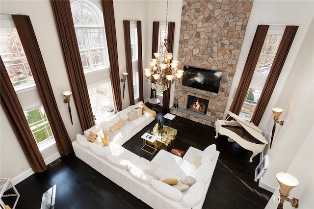 living room featuring a fireplace, a high ceiling, dark hardwood / wood-style floors, and a wealth of natural light