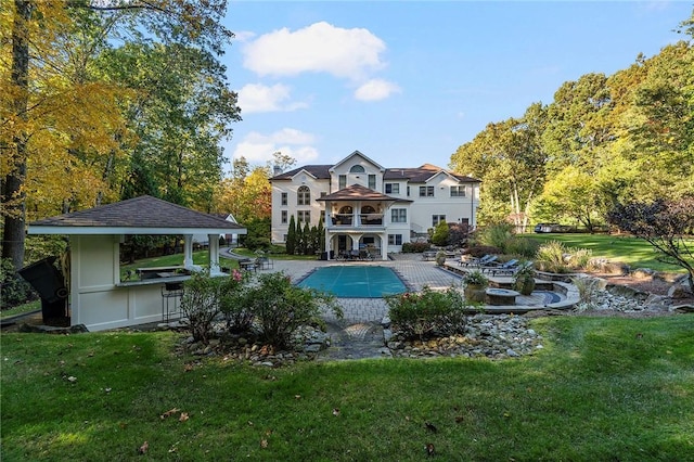 view of pool with a gazebo, a yard, a bar, and a patio