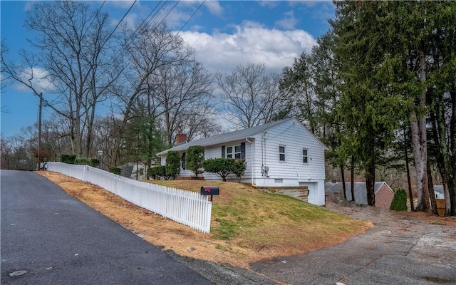 view of side of property with a garage and a lawn