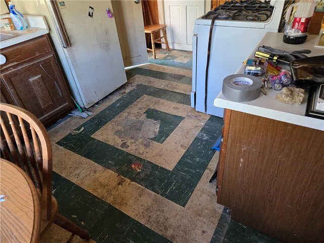 kitchen featuring white fridge and washer / dryer