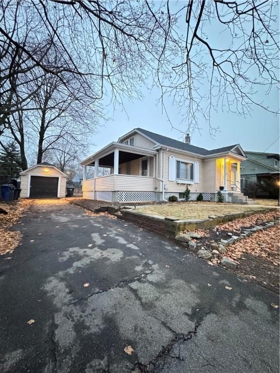 view of front of house with an outbuilding, a porch, and a garage