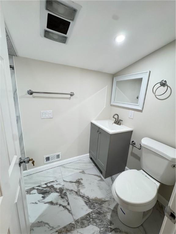 bathroom featuring vanity, toilet, and lofted ceiling