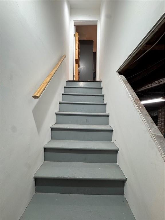 stairs featuring concrete flooring